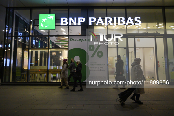 People walk past a BNP Paribas bank in Warsaw, Poland, on November 25, 2024. 