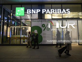 People walk past a BNP Paribas bank in Warsaw, Poland, on November 25, 2024. (