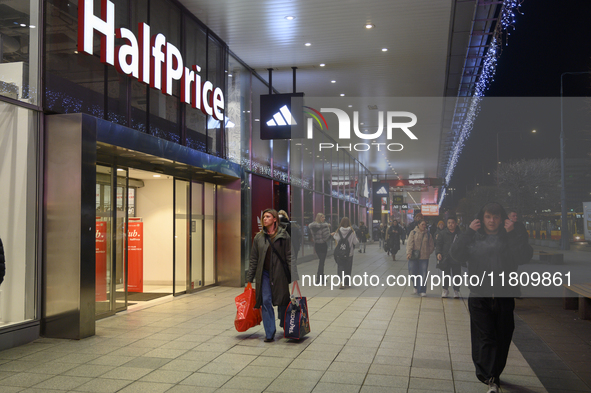 People walk past shops during Black Friday week in Warsaw, Poland, on November 25, 2024. 