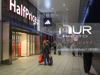 People walk past shops during Black Friday week in Warsaw, Poland, on November 25, 2024. (