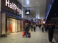 People walk past shops during Black Friday week in Warsaw, Poland, on November 25, 2024. (