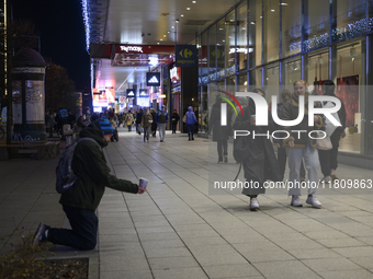 People walk past shops during Black Friday week in Warsaw, Poland, on November 25, 2024. (