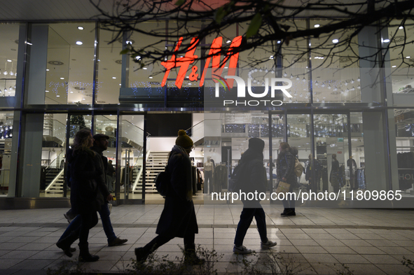 People walk past an H&M store during Black Friday week in Warsaw, Poland, on November 25, 2024. 