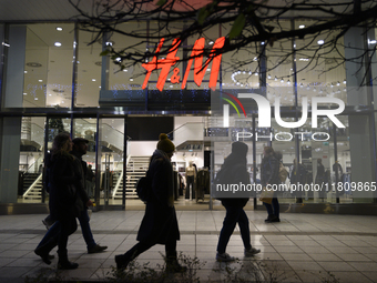 People walk past an H&M store during Black Friday week in Warsaw, Poland, on November 25, 2024. (