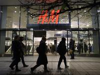 People walk past an H&M store during Black Friday week in Warsaw, Poland, on November 25, 2024. (