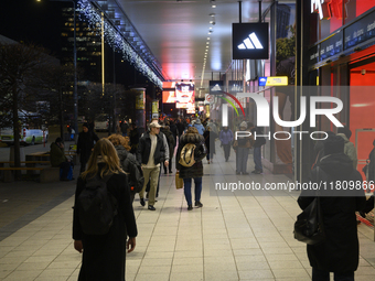 People walk past shops during Black Friday week in Warsaw, Poland, on November 25, 2024. (