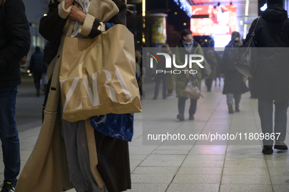 People walk past shops during Black Friday week in Warsaw, Poland, on November 25, 2024. 