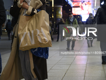 People walk past shops during Black Friday week in Warsaw, Poland, on November 25, 2024. (