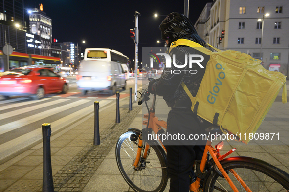 A Glovo delivery man checks his smartphone in Warsaw, Poland, on November 25, 2024. 