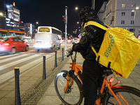 A Glovo delivery man checks his smartphone in Warsaw, Poland, on November 25, 2024. (