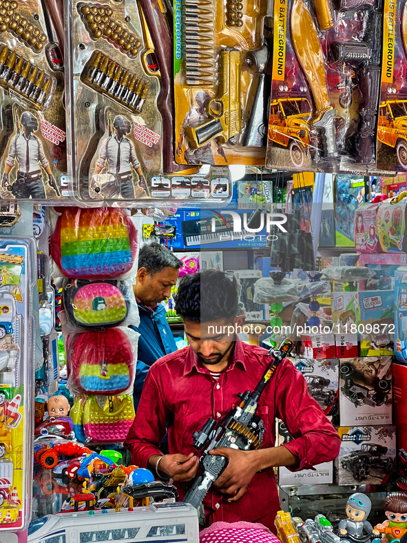 A shopkeeper holds a toy gun at a toy shop in the Bhutia Bazaar (Tibetan Market) in Nainital, Uttarakhand, India, on April 19, 2024. The Tib...