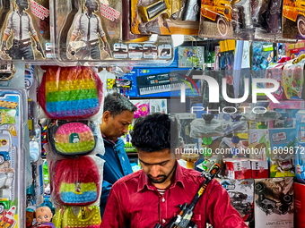 A shopkeeper holds a toy gun at a toy shop in the Bhutia Bazaar (Tibetan Market) in Nainital, Uttarakhand, India, on April 19, 2024. The Tib...