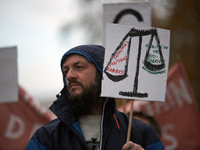 A protester holds a placard depicting Justice's scale with 'Corporate, politicians, lobbies' on one side and 'Environment, biodiversity, qua...