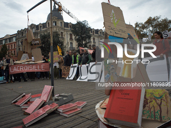 An Environment code is pictured during the gathering. People gather in Toulouse, France, on November 25, 2024, as plaintiffs (LVEL, Attac, A...