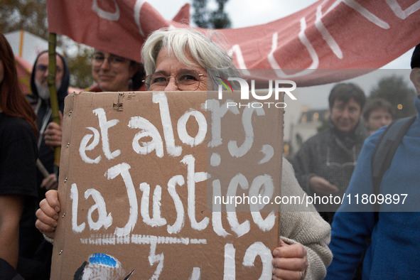 A woman holds a placard reading 'Then justice?' as people gather in Toulouse, France, on November 25, 2024, as plaintiffs (LVEL, Attac, Amis...