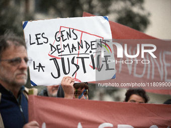 An opponent holds a cardboard sign reading 'People ask for justice'. People gather in Toulouse, France, on November 25, 2024, as plaintiffs,...