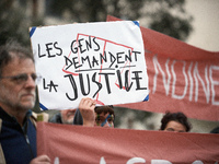 An opponent holds a cardboard sign reading 'People ask for justice'. People gather in Toulouse, France, on November 25, 2024, as plaintiffs,...