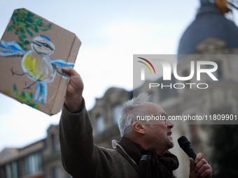 An opponent holds a cardboard sign with a message. People gather in Toulouse, France, on November 25, 2024, as plaintiffs, including LVEL, A...