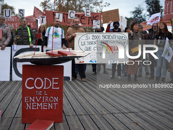 An Environment code is pictured during the gathering. People gather in Toulouse, France, on November 25, 2024, as plaintiffs (LVEL, Attac, A...