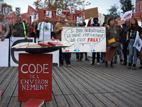 An Environment code is pictured during the gathering. People gather in Toulouse, France, on November 25, 2024, as plaintiffs (LVEL, Attac, A...