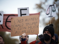 A man holds a placard reading 'A69 in the fire, Donald Trump and Elon Musk in the middle'. People gather in Toulouse, France, on November 25...