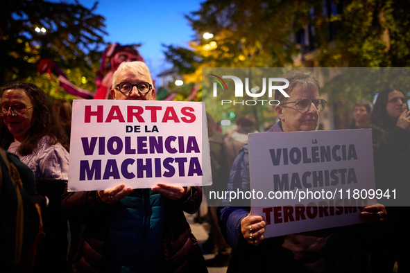 Two protesters hold banners reading 'Fed up with gender violence' and 'Gender-based violence is terrorism' during the 25N demonstration, Int...