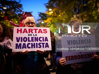 Two protesters hold banners reading 'Fed up with gender violence' and 'Gender-based violence is terrorism' during the 25N demonstration, Int...