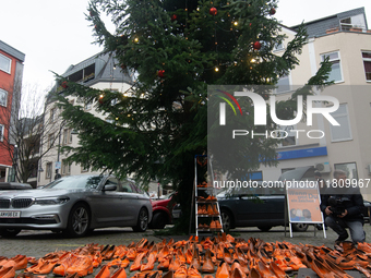 Orange shoes are displayed under a Christmas tree as a symbol against violence against women in Cologne, Germany, on November 25, 2024, duri...