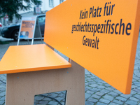 An orange bench with the message ''no place for violence against women'' is seen near a Christmas tree as a symbol against violence against...