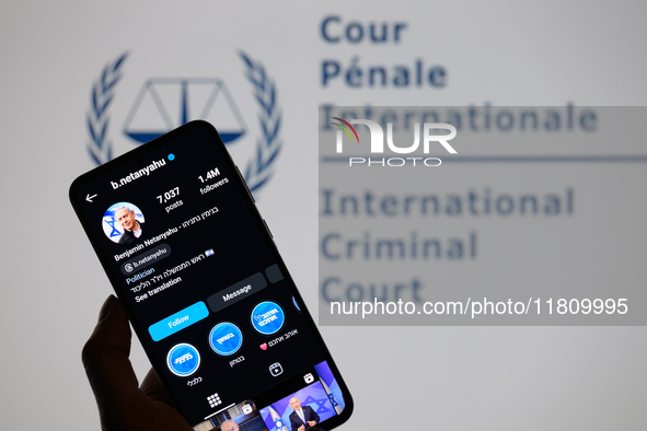 Benjamin Netanyahu's social media is displayed on a smartphone with the International Criminal Court logo visible in the background in this...