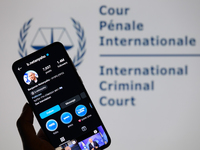 Benjamin Netanyahu's social media is displayed on a smartphone with the International Criminal Court logo visible in the background in this...