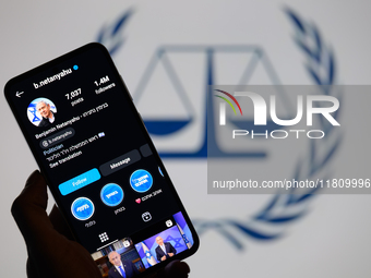 Benjamin Netanyahu's social media is displayed on a smartphone with the International Criminal Court logo visible in the background in this...