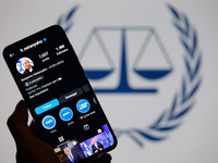 Benjamin Netanyahu's social media is displayed on a smartphone with the International Criminal Court logo visible in the background in this...