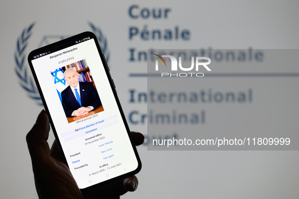 Benjamin Netanyahu appears on a smartphone with the International Criminal Court logo visible in the background in this photo illustration i...