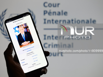 Benjamin Netanyahu appears on a smartphone with the International Criminal Court logo visible in the background in this photo illustration i...