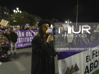 A young woman with a megaphone shouts slogans against sexism during the demonstration for the International Day for the Elimination of Viole...