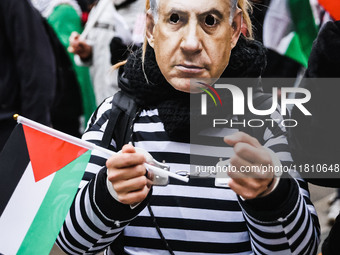 Demonstrators wear a mask of Benjamin Netanyahu during a pro-Palestinian protest in Piazza Duomo in Milan, Italy, on November 23, 2024 (