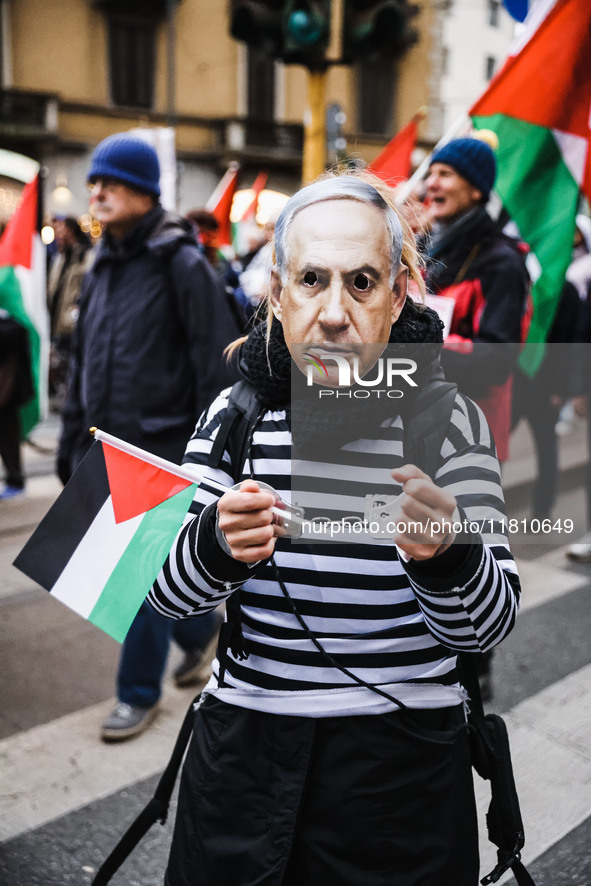 Demonstrators wear a mask of Benjamin Netanyahu during a pro-Palestinian protest in Piazza Duomo in Milan, Italy, on November 23, 2024 