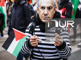 Demonstrators wear a mask of Benjamin Netanyahu during a pro-Palestinian protest in Piazza Duomo in Milan, Italy, on November 23, 2024 (