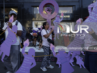 Mothers, relatives of missing persons and victims of femicide, feminist collectives, and various organizations hold silhouettes while protes...