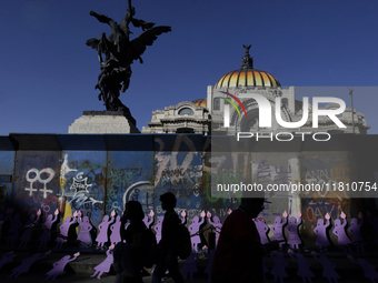 Silhouettes of mothers, relatives of missing persons and victims of femicide, feminist collectives, and various organizations protest outsid...