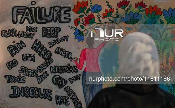 A college student looks at the graffiti on a wall in Srinagar, Jammu and Kashmir, on November 26, 2024. In total, 11.3% of the adult populat...