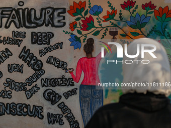 A college student looks at the graffiti on a wall in Srinagar, Jammu and Kashmir, on November 26, 2024. In total, 11.3% of the adult populat...