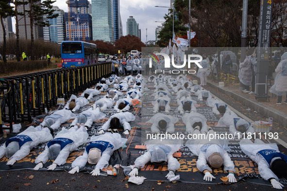 Members of the Korea Parents' Network for People with Disabilities perform the symbolic 'five-body prostration' protest in front of the Nati...