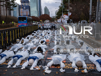 Members of the Korea Parents' Network for People with Disabilities perform the symbolic 'five-body prostration' protest in front of the Nati...