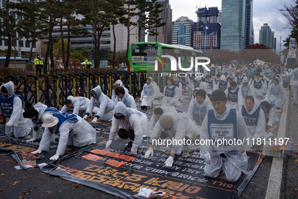 Members of the Korea Parents' Network for People with Disabilities perform the symbolic 'five-body prostration' protest in front of the Nati...