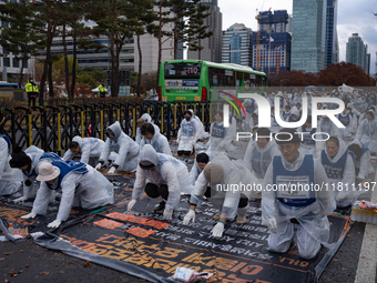 Members of the Korea Parents' Network for People with Disabilities perform the symbolic 'five-body prostration' protest in front of the Nati...