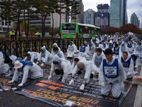 Members of the Korea Parents' Network for People with Disabilities perform the symbolic 'five-body prostration' protest in front of the Nati...