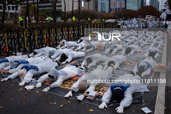 Members of the Korea Parents' Network for People with Disabilities perform the symbolic 'five-body prostration' protest in front of the Nati...