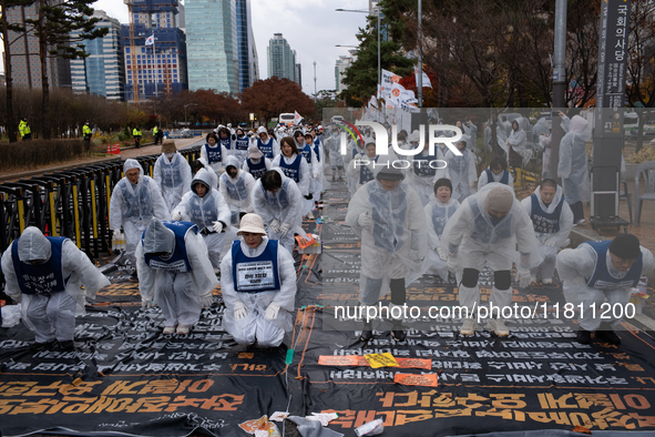 Members of the Korea Parents' Network for People with Disabilities perform the symbolic 'five-body prostration' protest in front of the Nati...